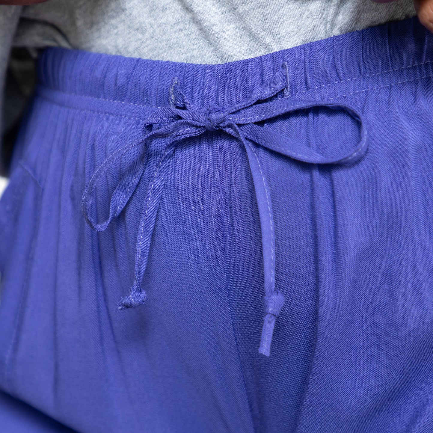 Close-up of a person wearing periwinkle shorts with a drawstring.