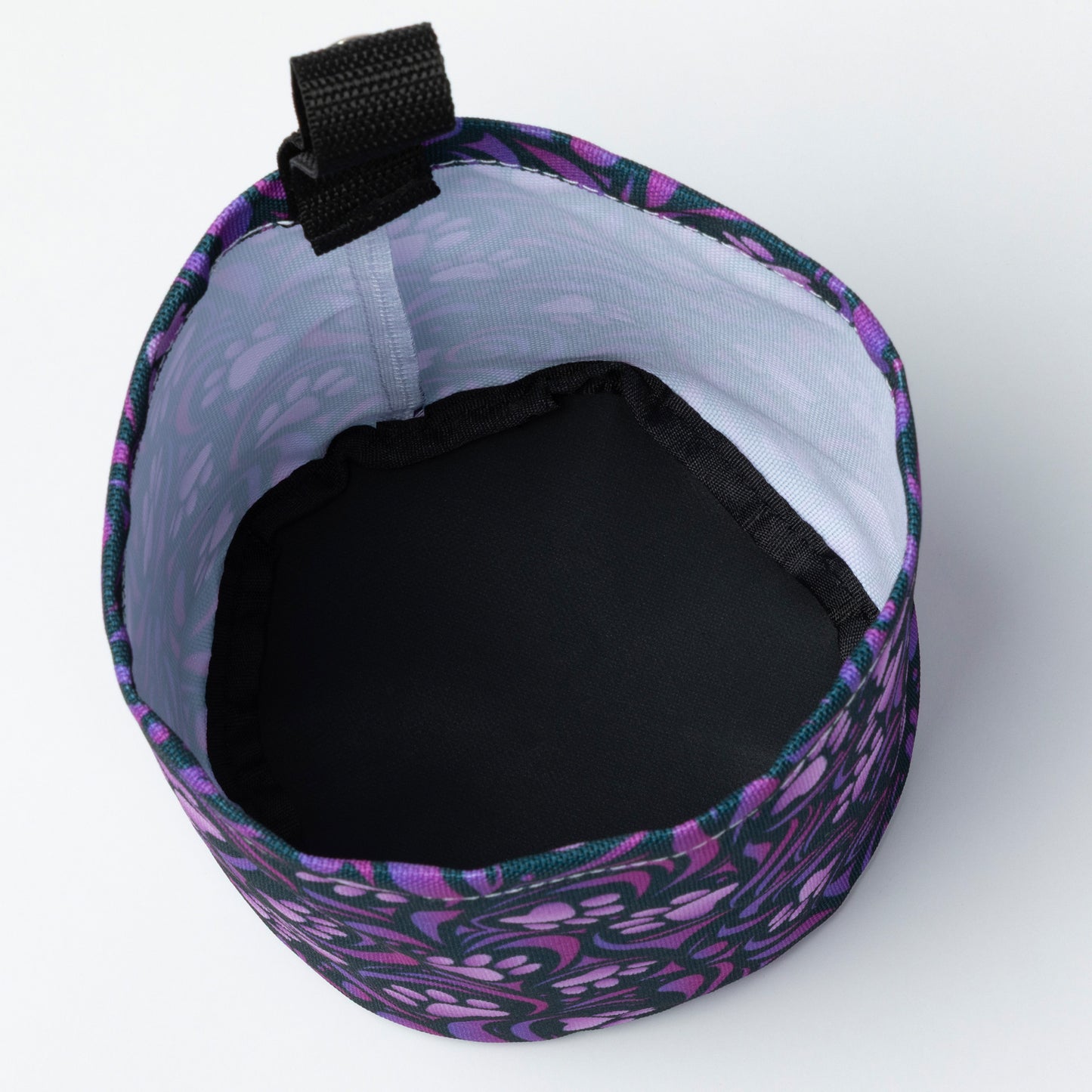Collapsible car garbage holder with purple paw print pattern on a white background. Inside of fabric is white and the bottom is black.