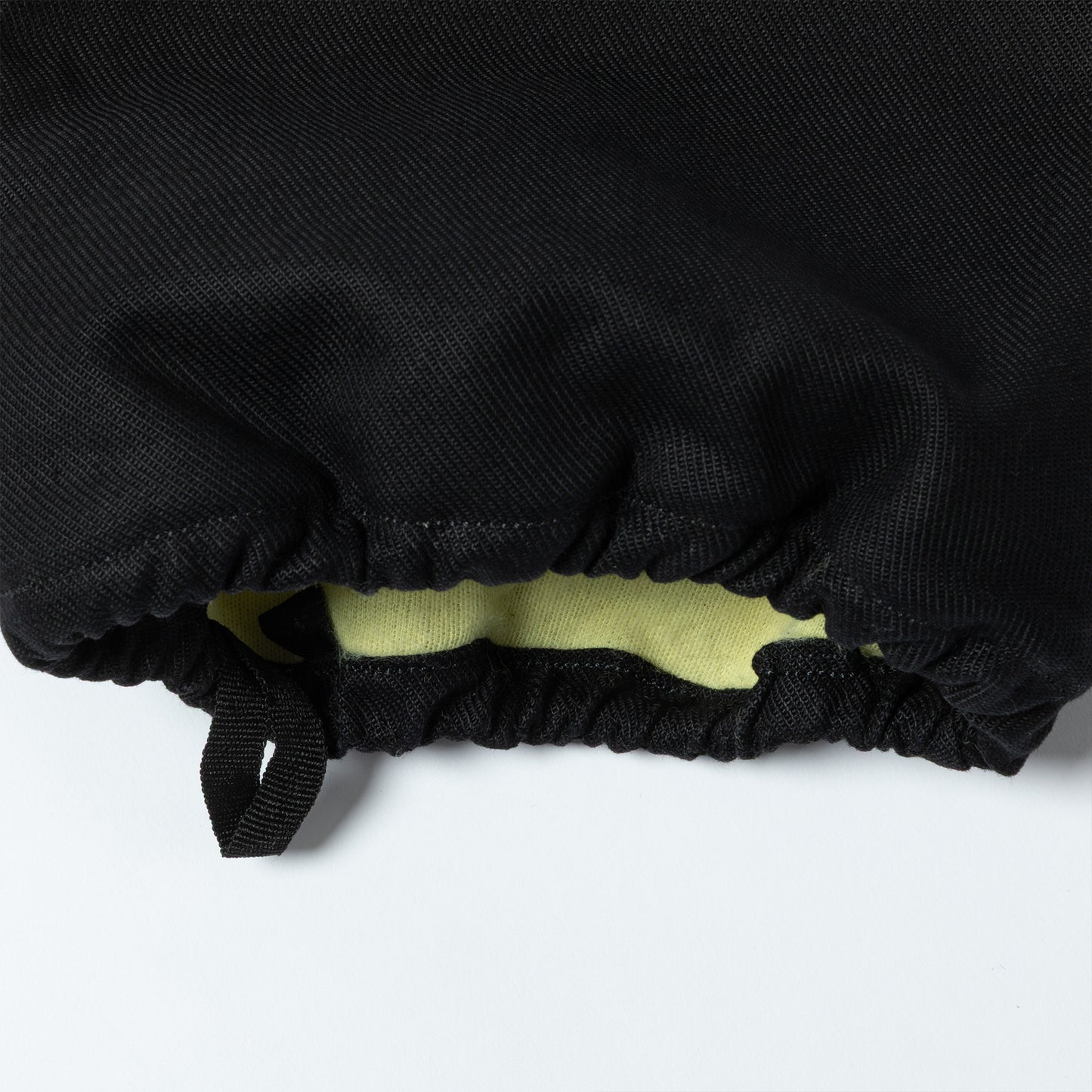 Close-up of black fabric with a yellow interior on a white background