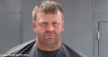 Mugshot-style photo of a man in front of a gray wall.