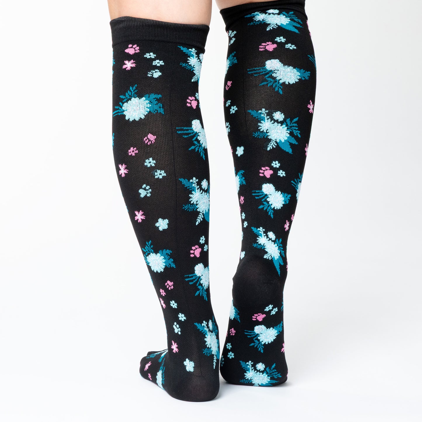 Black knee-high compression socks with floral pattern and paw prints on a white background.
