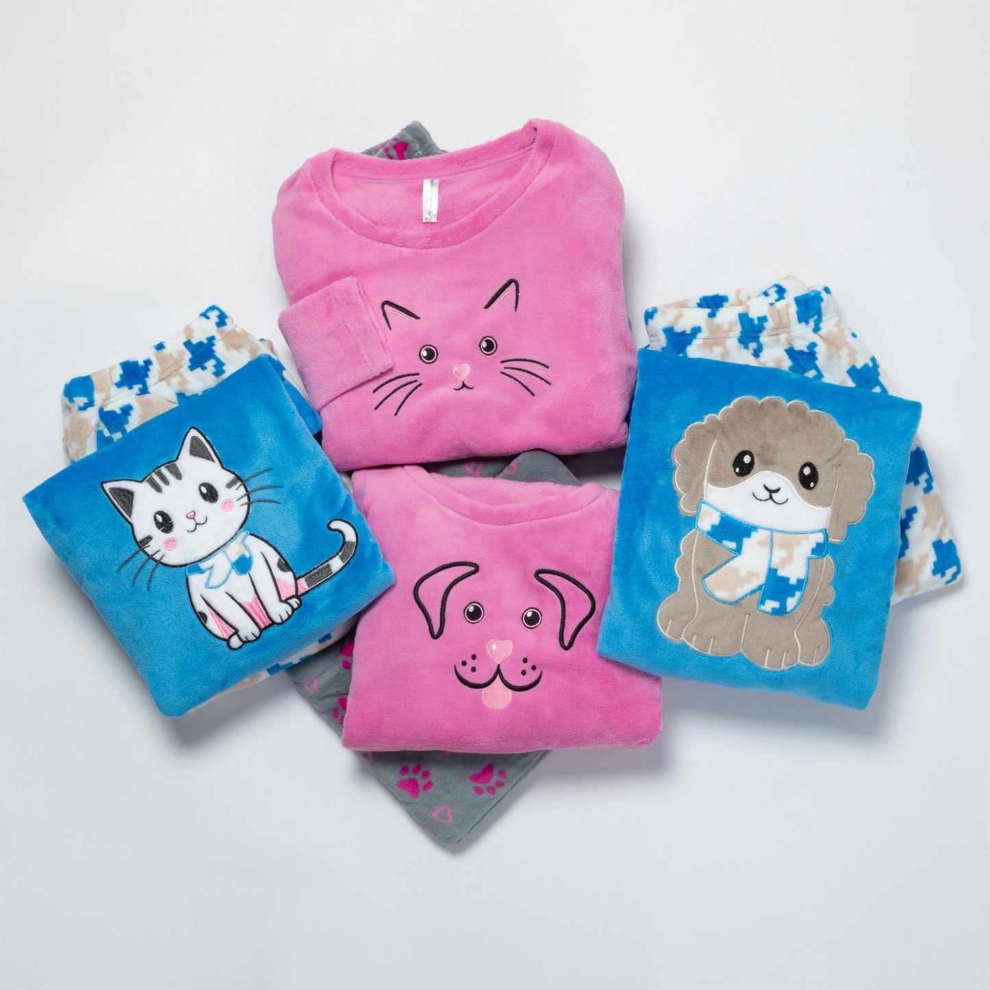 A collection of plush, warm pajama sets designed with cute dog and cat embroidery on a white background.