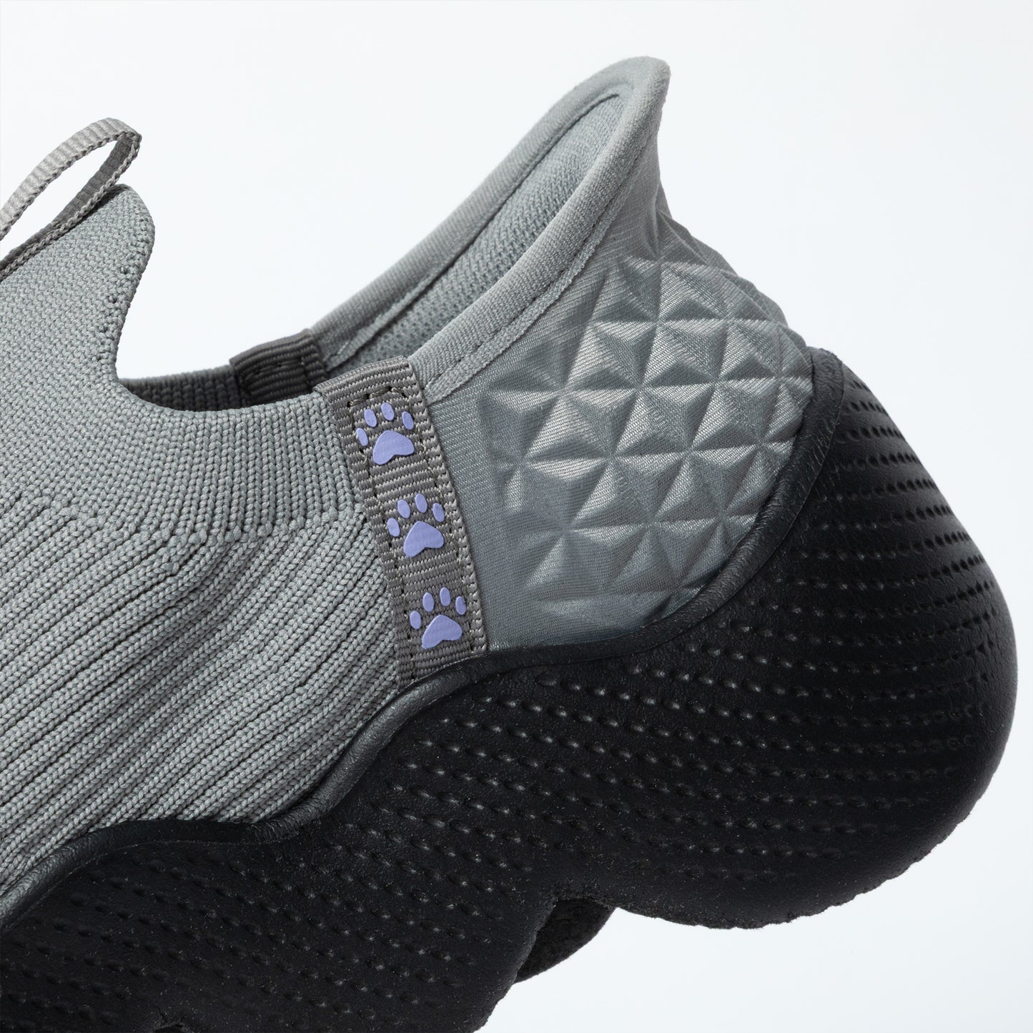 Gray slip on shoe with textured sole and paw pattern on a white background