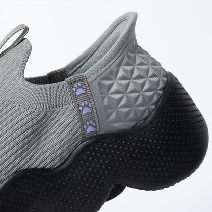 Gray slip on shoe with textured sole and paw pattern on a white background