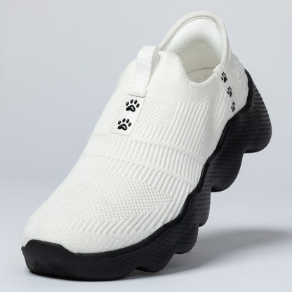 White slip-on shoe with black sole on a light gray background