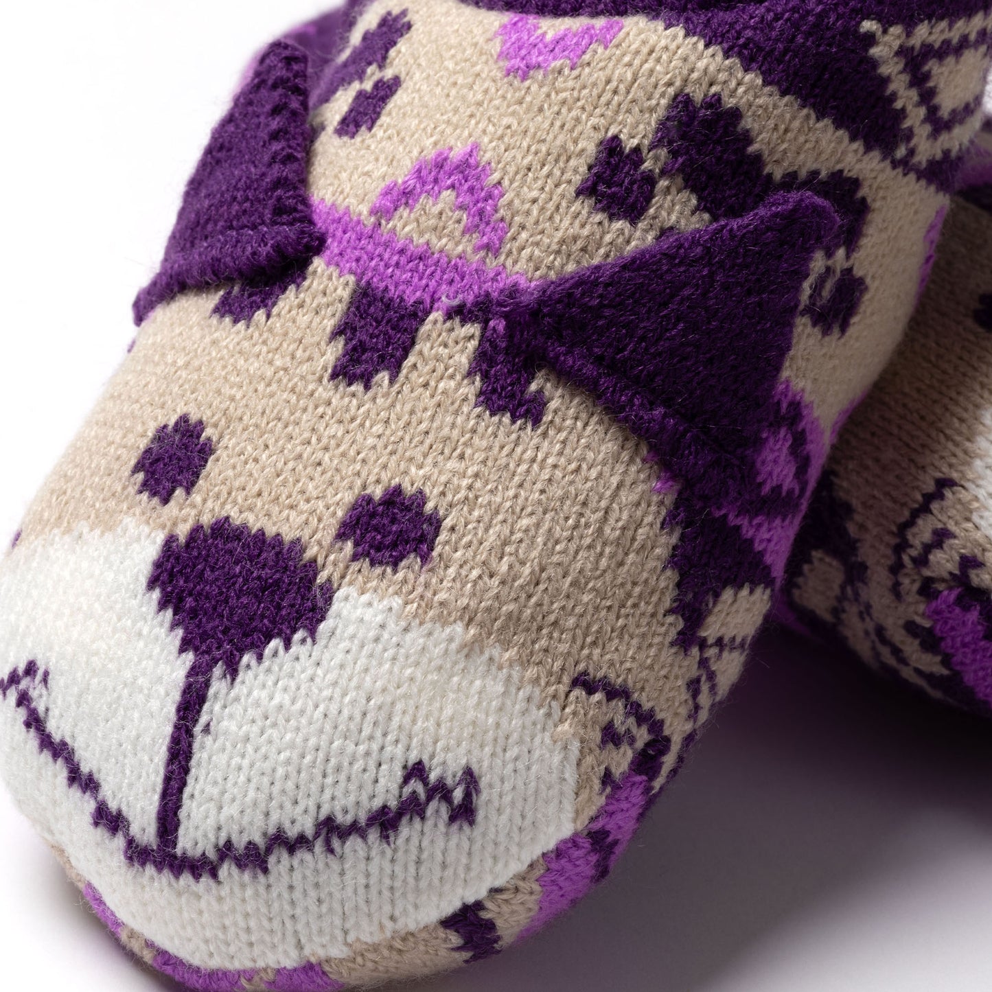 Knitted slipper sock with purple and beige cat face pattern on a white background beige cat