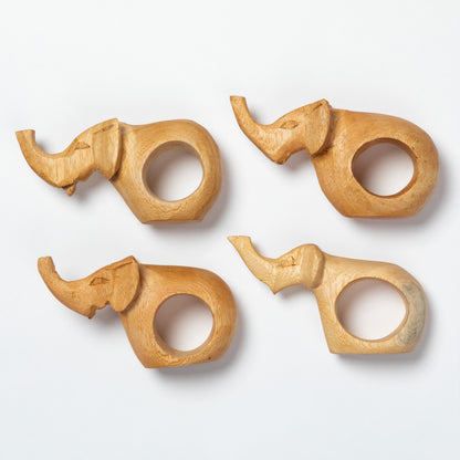 Four wooden elephant-shaped napkin rings on a white background.