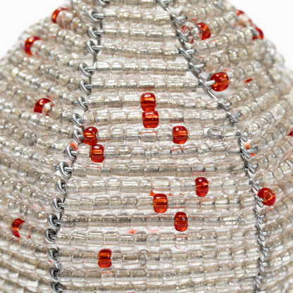 Close-up of a beaded necklace with red and clear beads on a white background