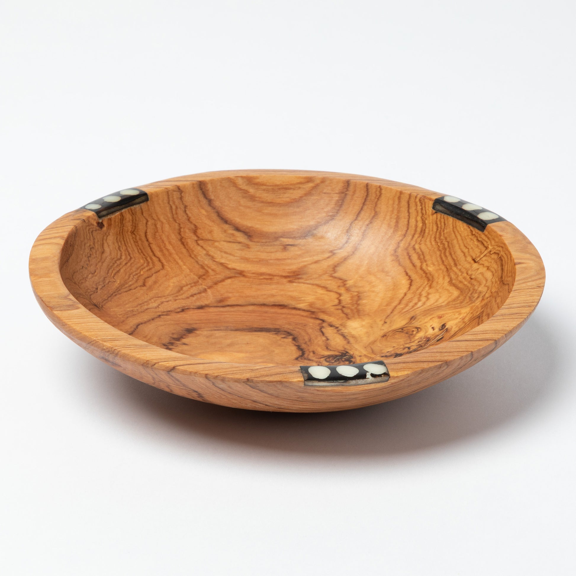 Wooden bowl with a decorative bone accent on a white background