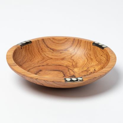 Wooden bowl with a decorative bone accent on a white background