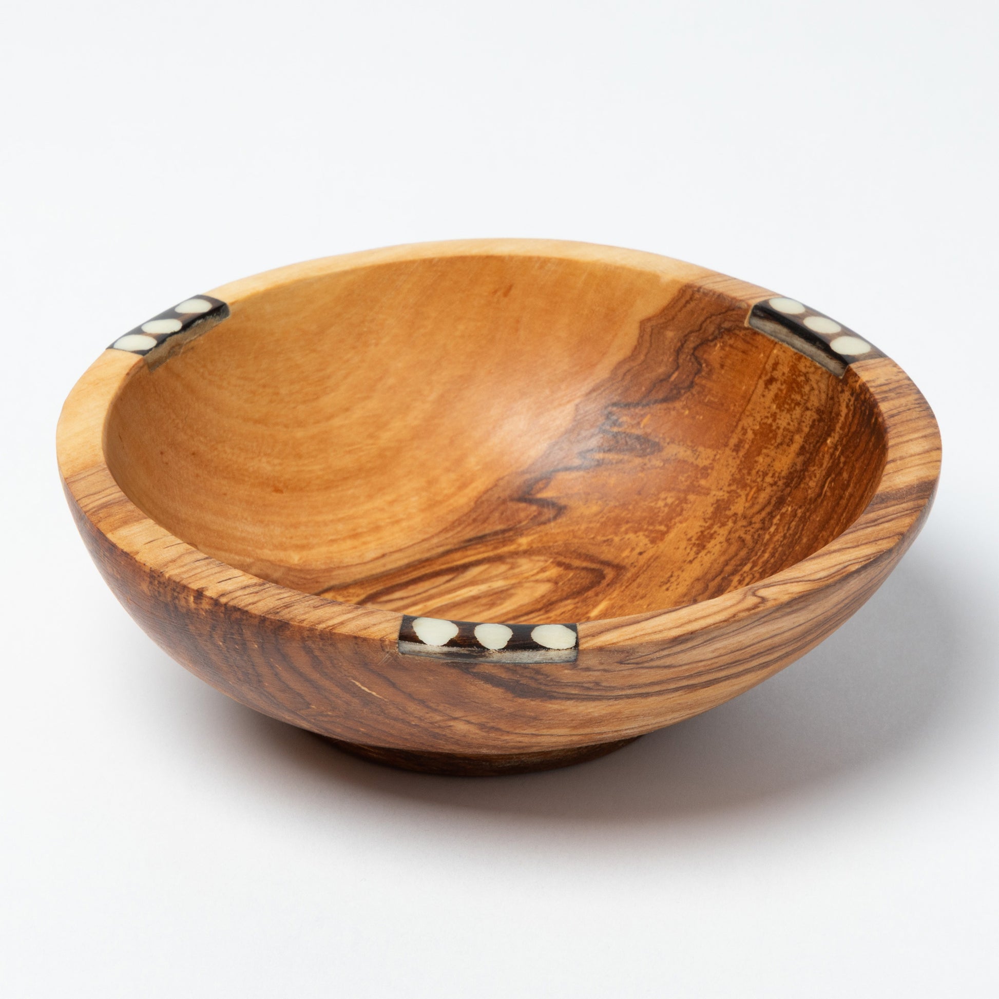 Wooden bowl with inlaid decorative elements on a white background