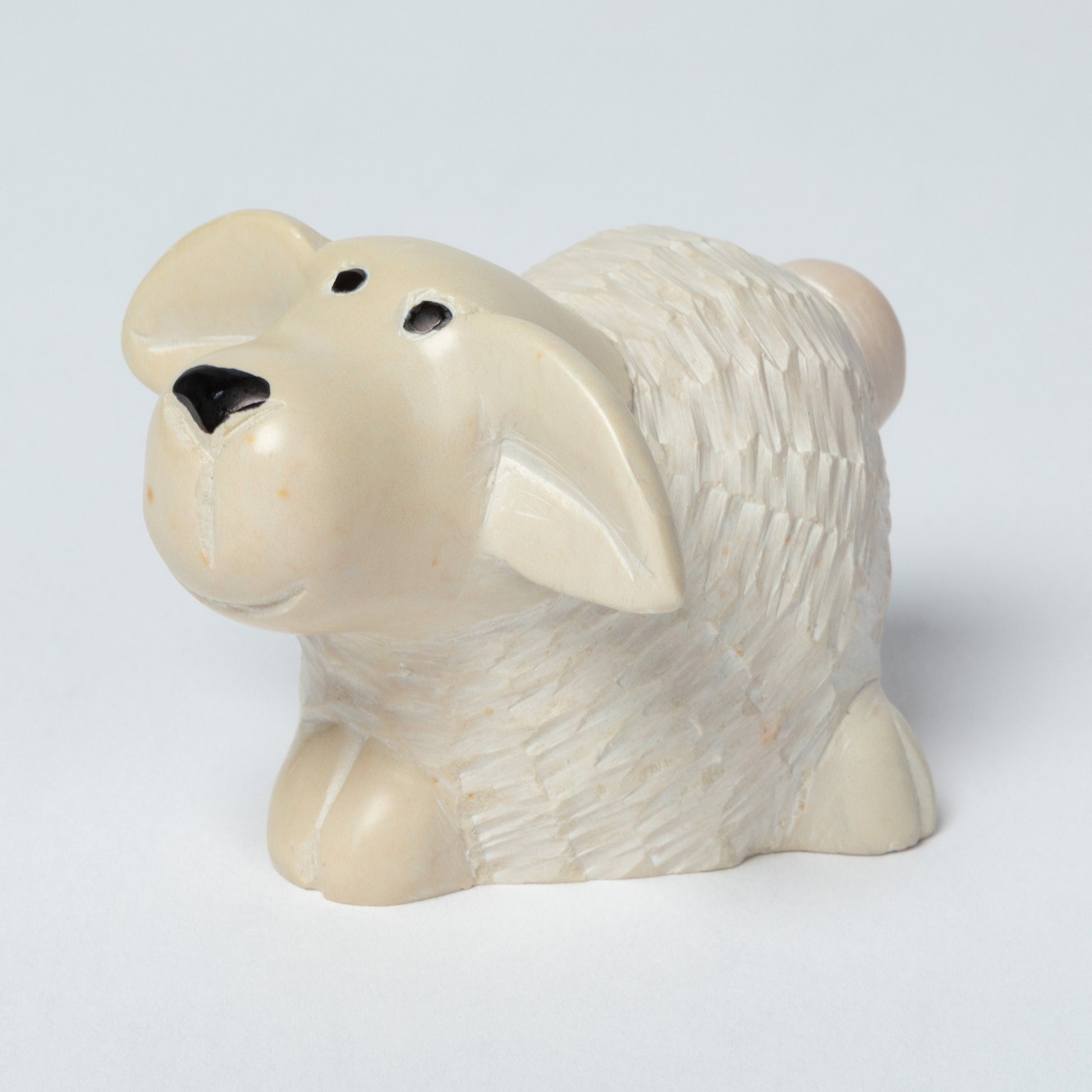 Soapstone sheep figurine on a light gray background