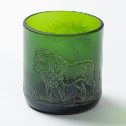 Green glass tumbler with a lion engraving on a white background