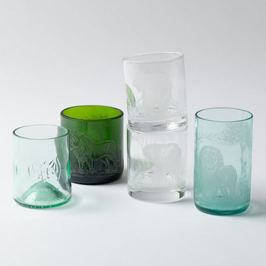 Four glass tumblers in different colors on a white background