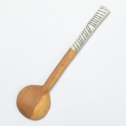 Wooden spoon with a textured handle on a white background