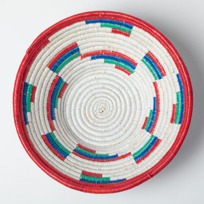 Woven basket with concentric circles of red, blue, and green on a white background