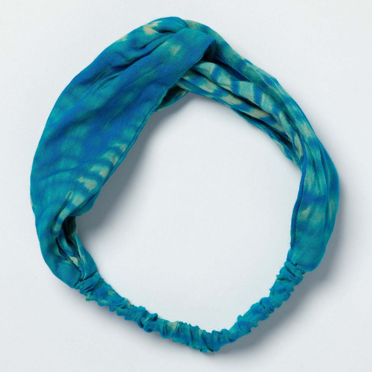 Blue tie-dye headband on a light gray background