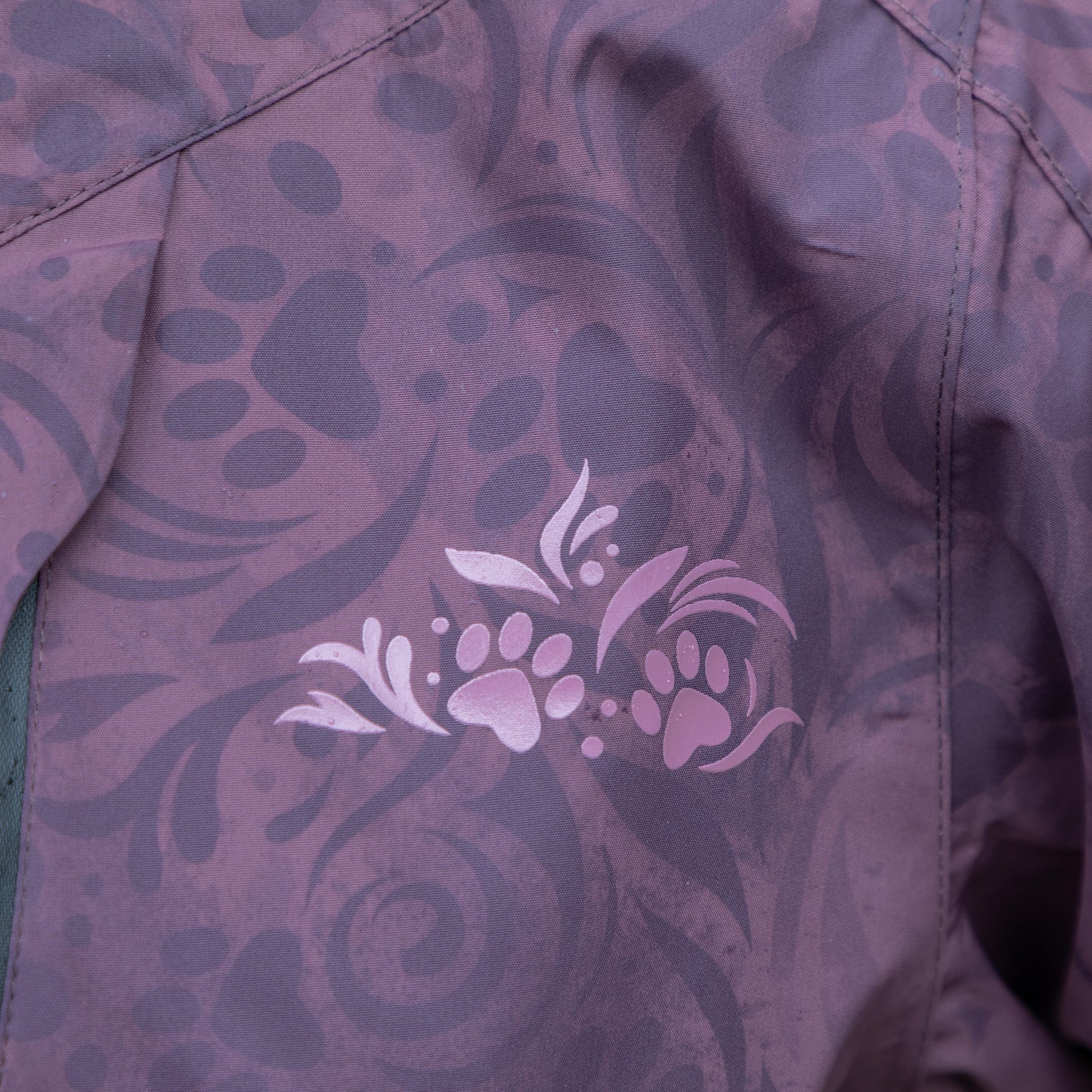 Close-up of a purple paw design on purple fabric with floral pattern