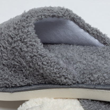 Gray fuzzy slippers with a textured surface on a light gray background