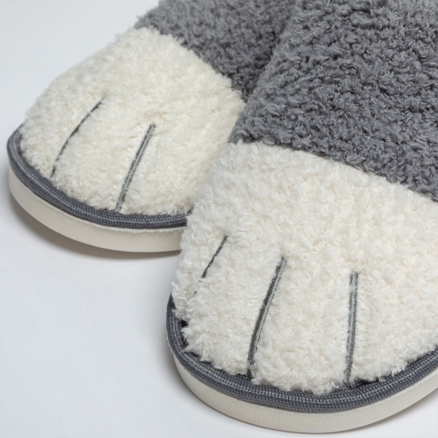 Pair of gray and white slippers on a light gray background
