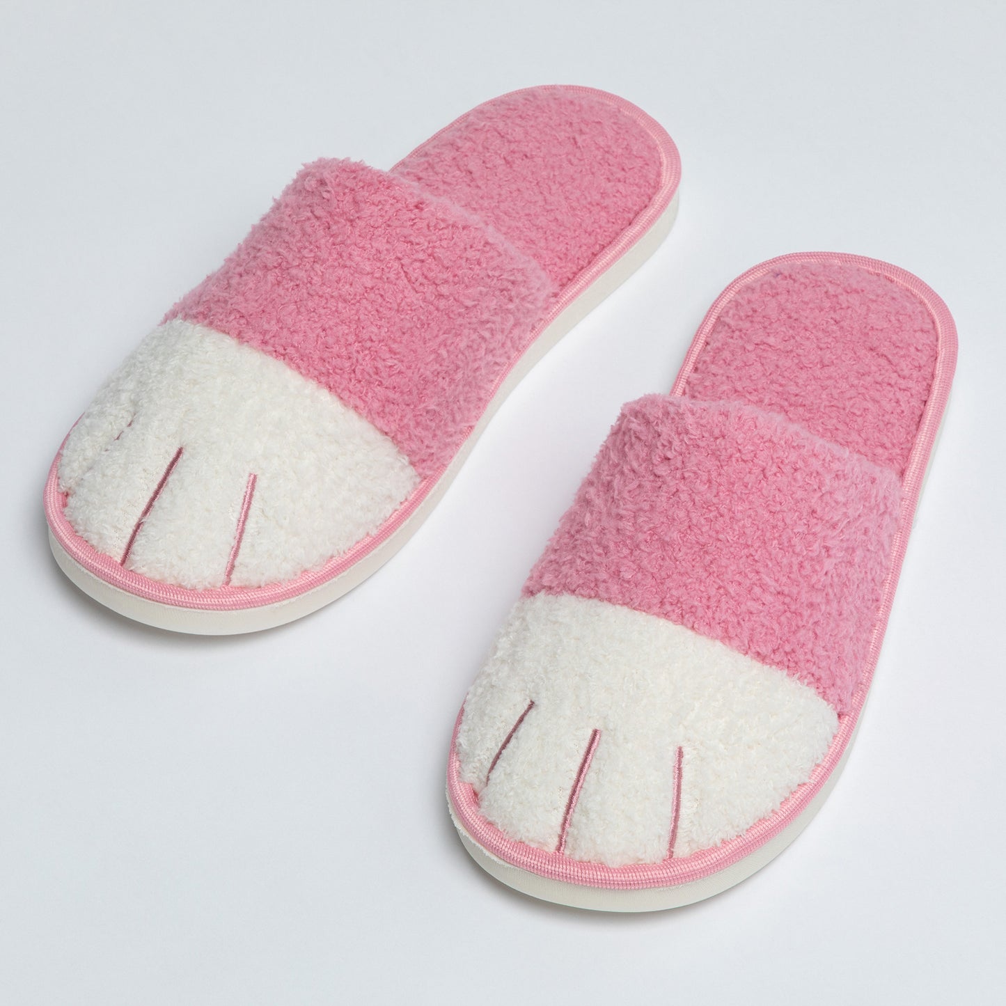 Pair of pink and white slippers on a light gray background