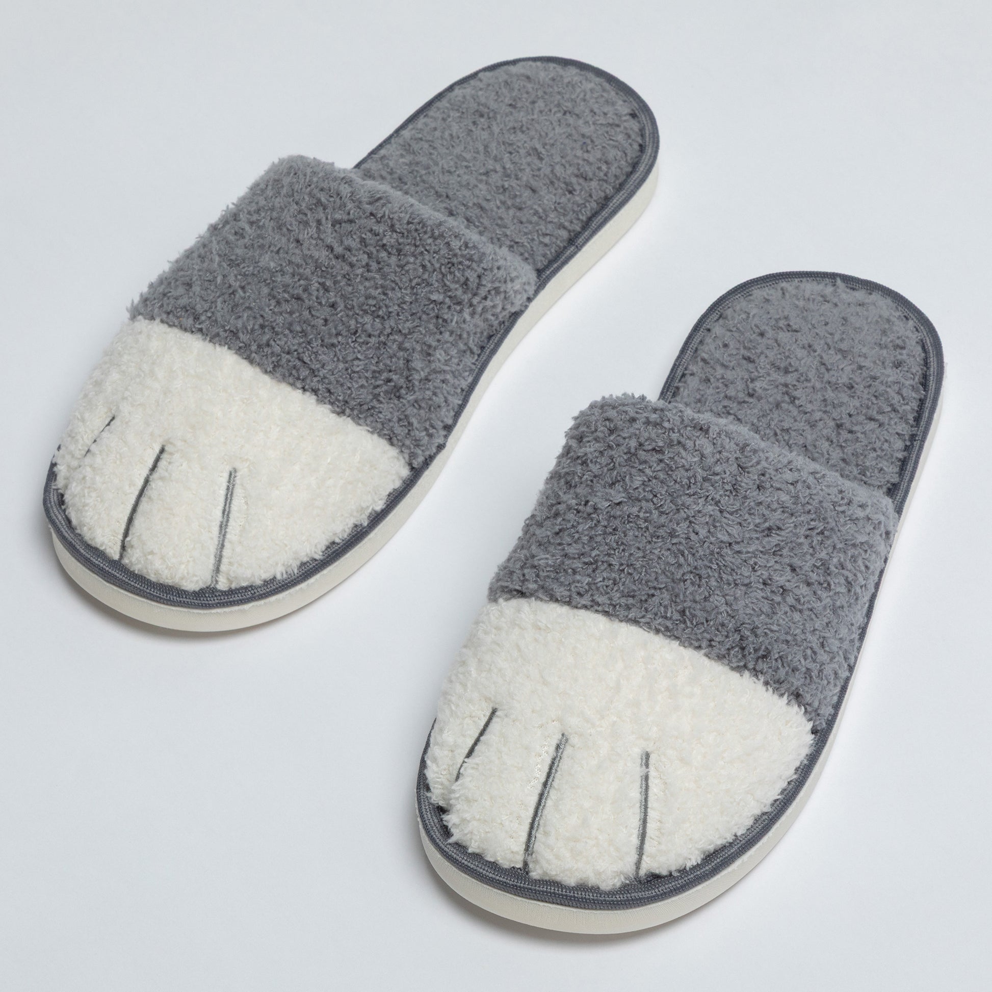Pair of gray and white slippers on a light gray background