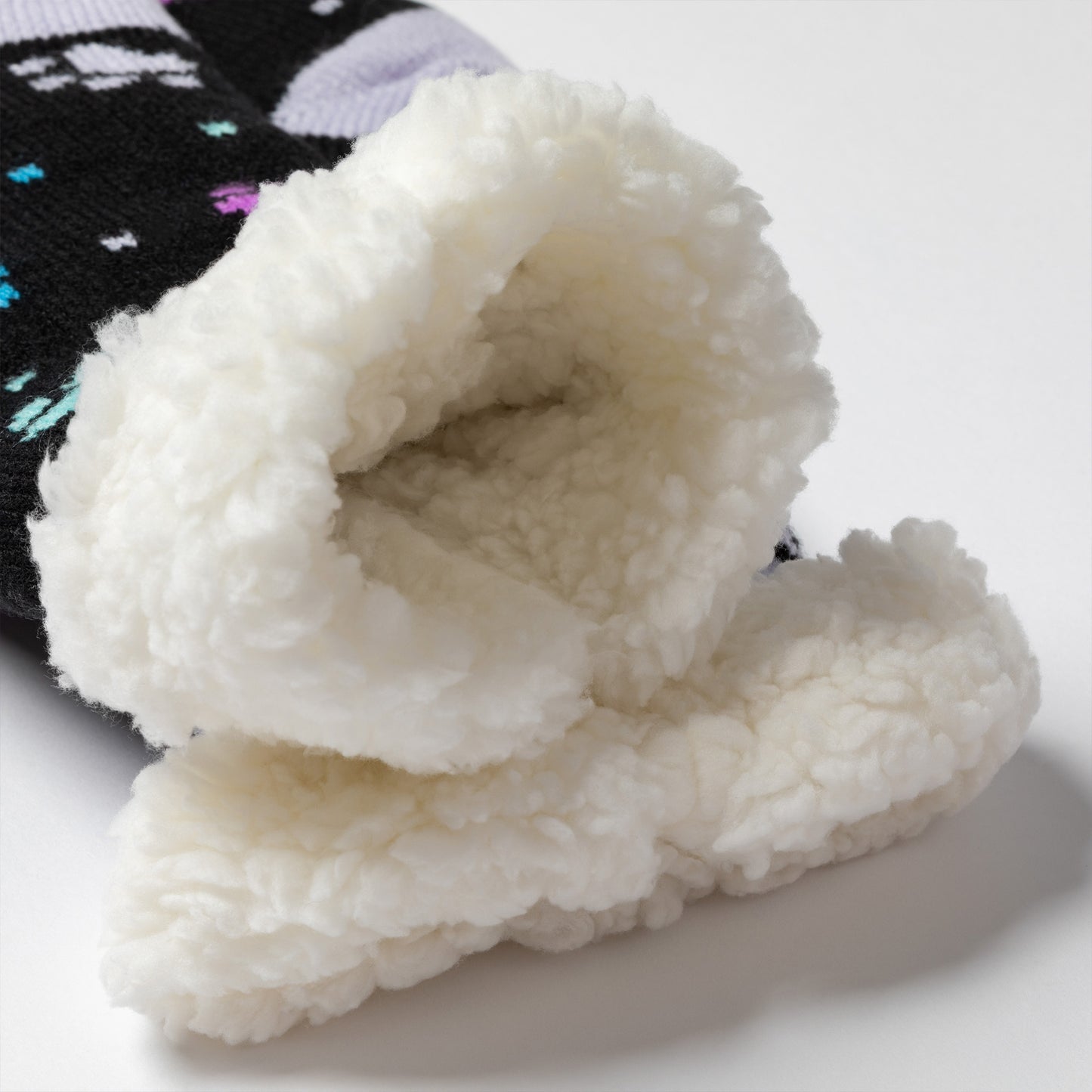 detail Pair of black with purple and blue polka dot paws Sherpa Fleece Lined Paw Print Cabin Slipper Socks with sherpa trim on a light gray background polka dot paws showing plush sherpa interior  