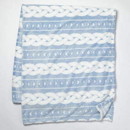 Blue blanket with white braided pattern on a light gray background