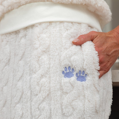 One of the two side pockets with a hand in it. The pocket has the cable knit patterned and has two light blue paw prints embroidered in the fleece fabric.