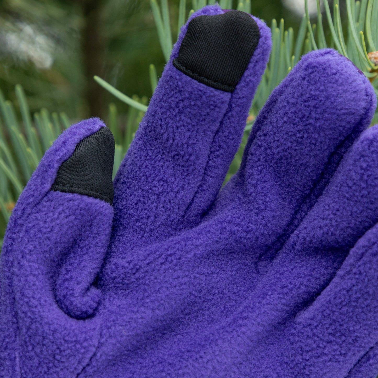 Purple gloves with black touch tips on a green background