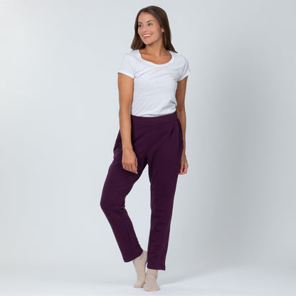 Woman wearing a white top and purple pants on a white background