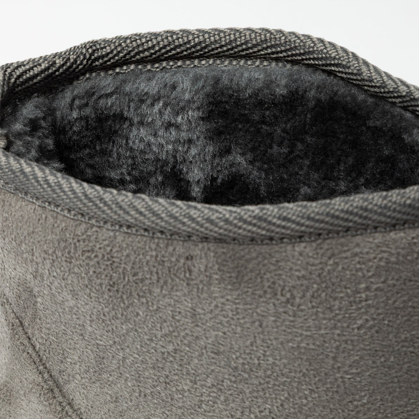 Close-up of a textured gray fabric with a soft black interior lining.