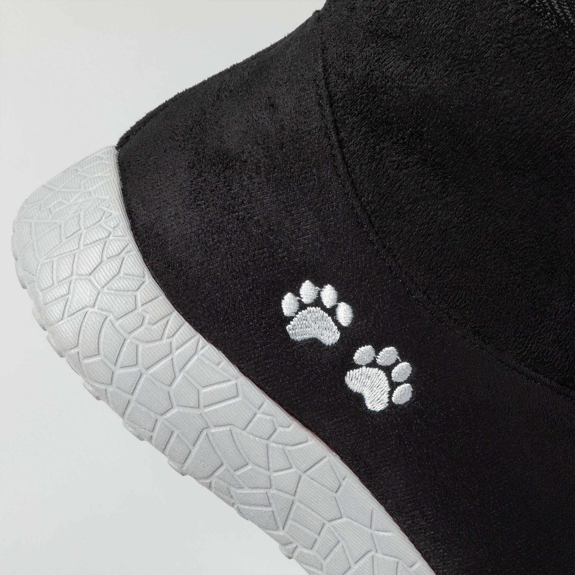 Black shoe with white paw prints on a gray background