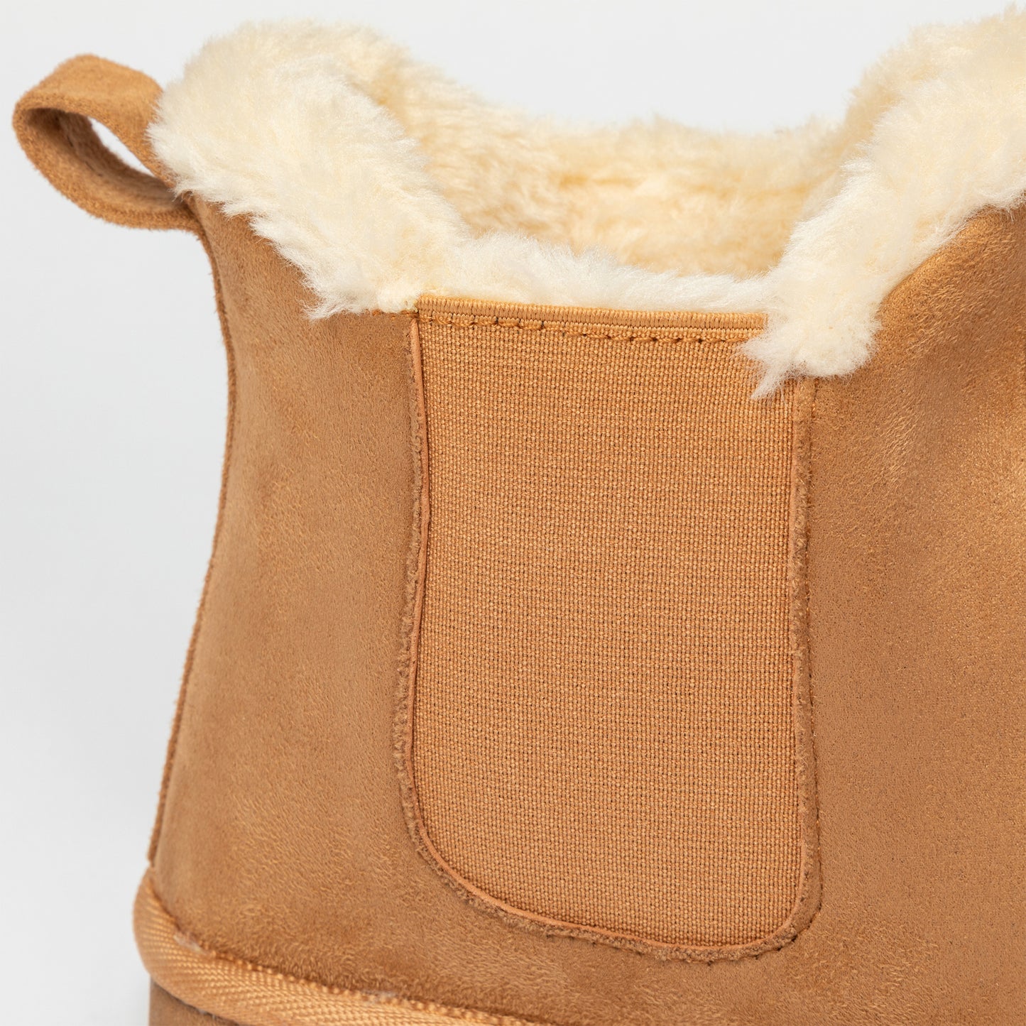 Close-up of a brown suede boot with white fur lining on a light gray background