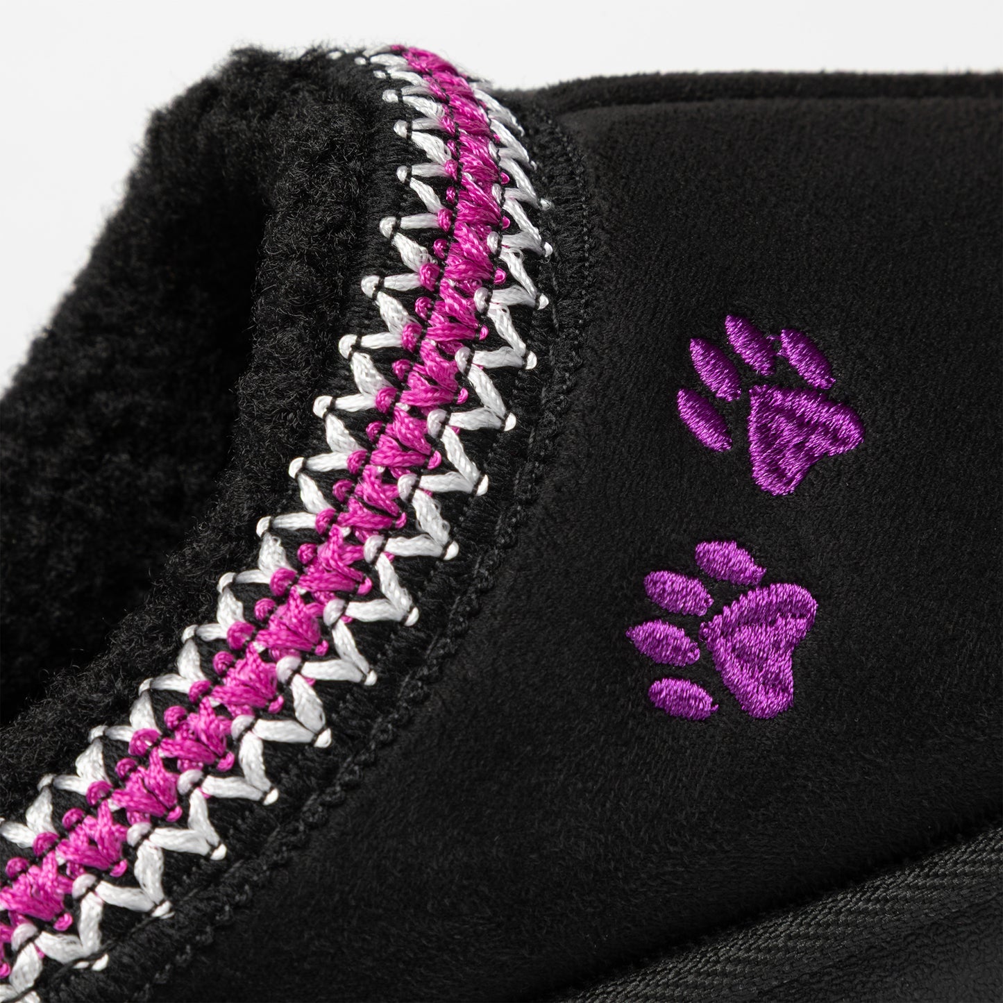 Close up of black slippers with fuchsia and white trim, a pair of purple embroidered paws on the side, on a white background.