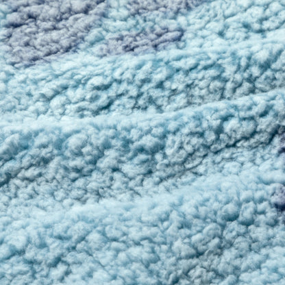 A close-up of a plush, textured fabric in a light sky blue color with subtle tonal variations.