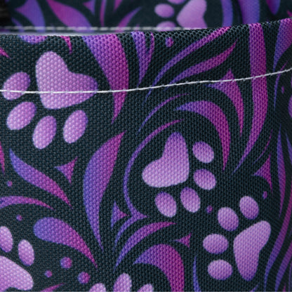 Close-up of fabric with purple paw print pattern on black background