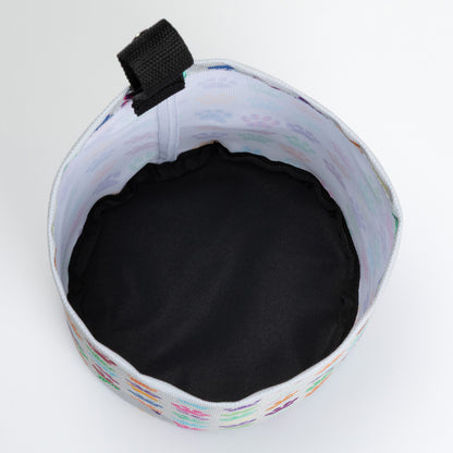 Collapsible car garbage holder with paw print pattern on a white background. Inside of fabric is white and the bottom is black. 