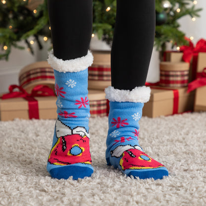 Colorful Christmas-themed socks with paw prints worn indoors, with a decorated Christmas tree and presents in the background.