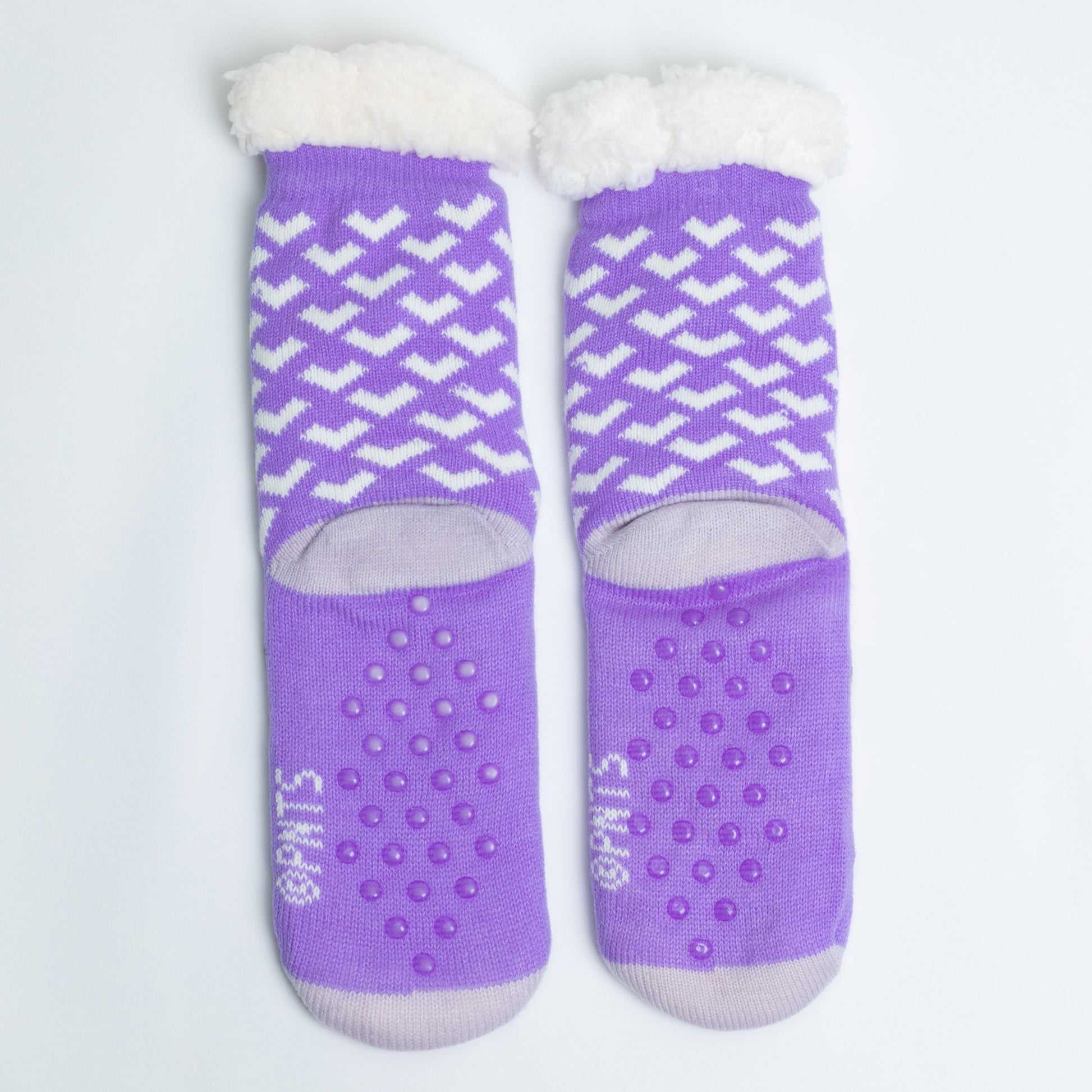 Pair of purple socks with white patterns and textured sole on a light gray background