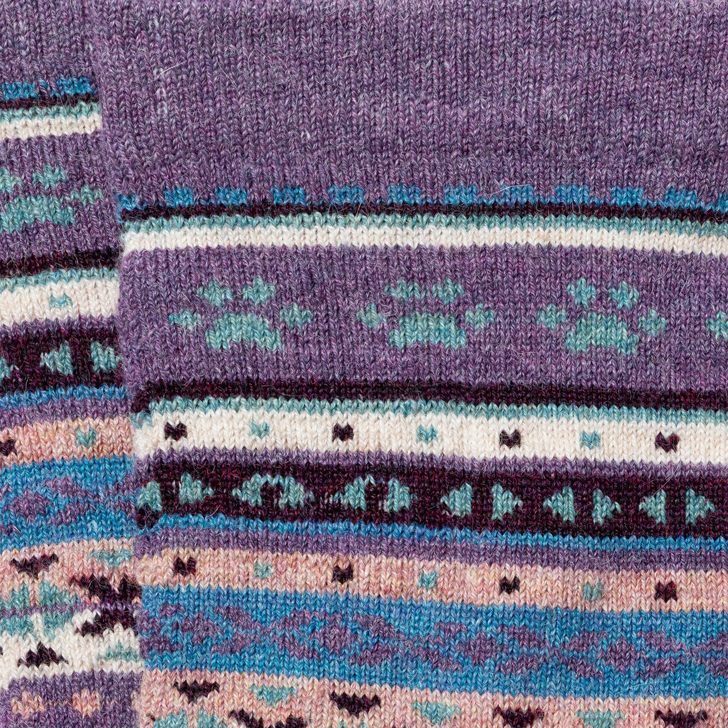 Close-up of a knitted fabric with a pattern of stripes and geometric shapes.