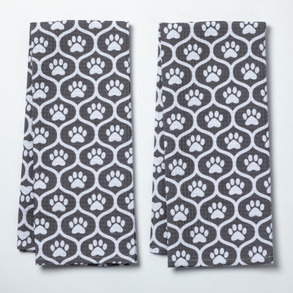 Two folded towels with a pattern of white paw prints on a gray background