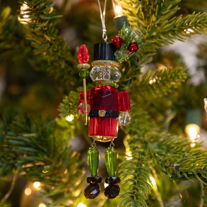 Decorative Christmas ornament on a tree with lights in the background