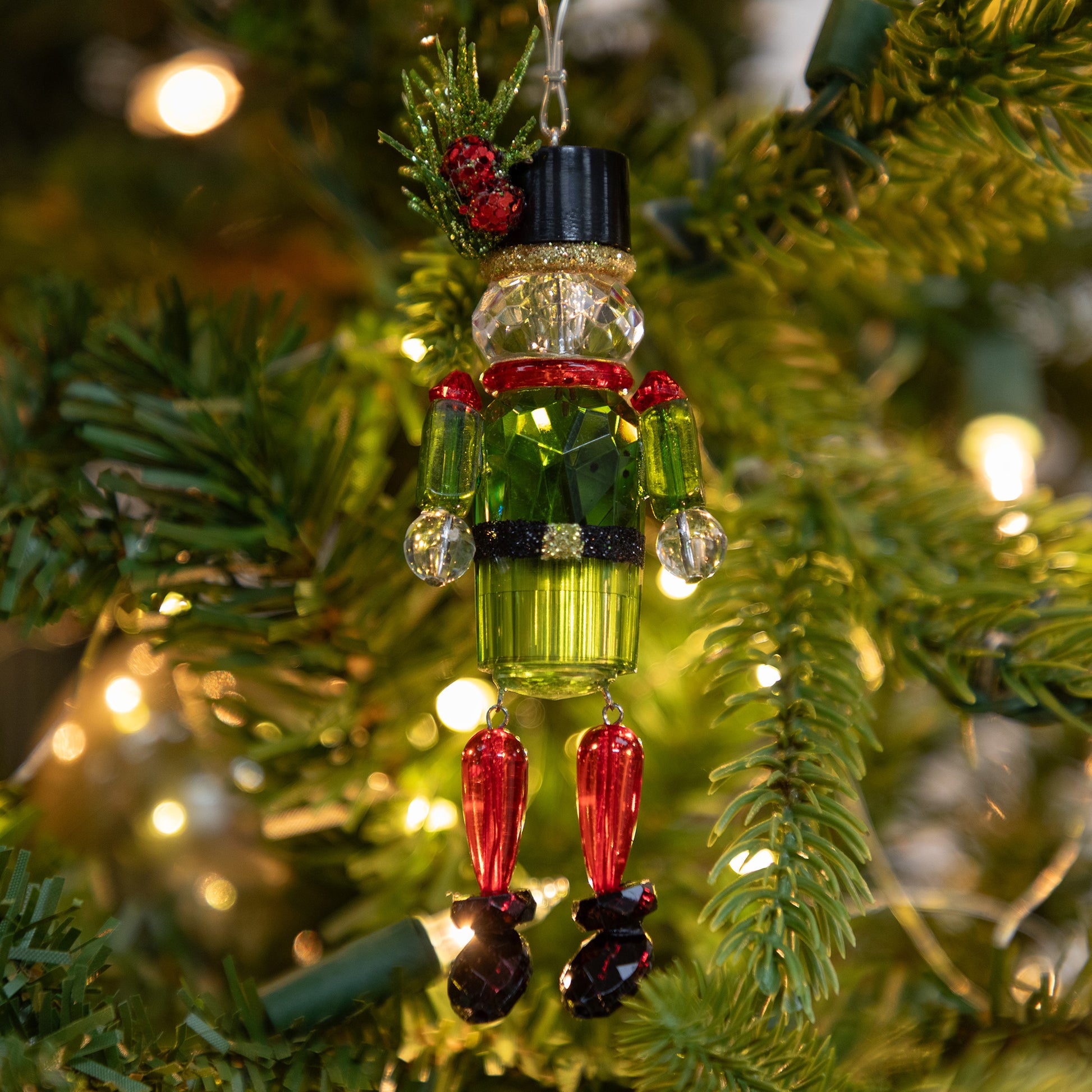Decorative Christmas ornament on a tree with lights in the background