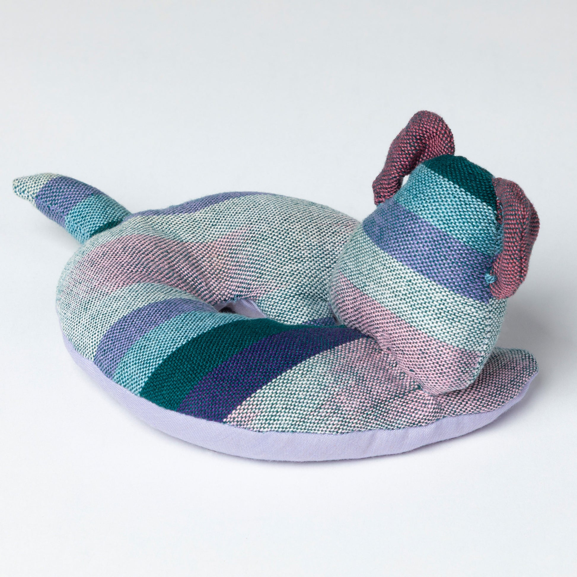 Colorful striped dog-shaped coaster on a white background