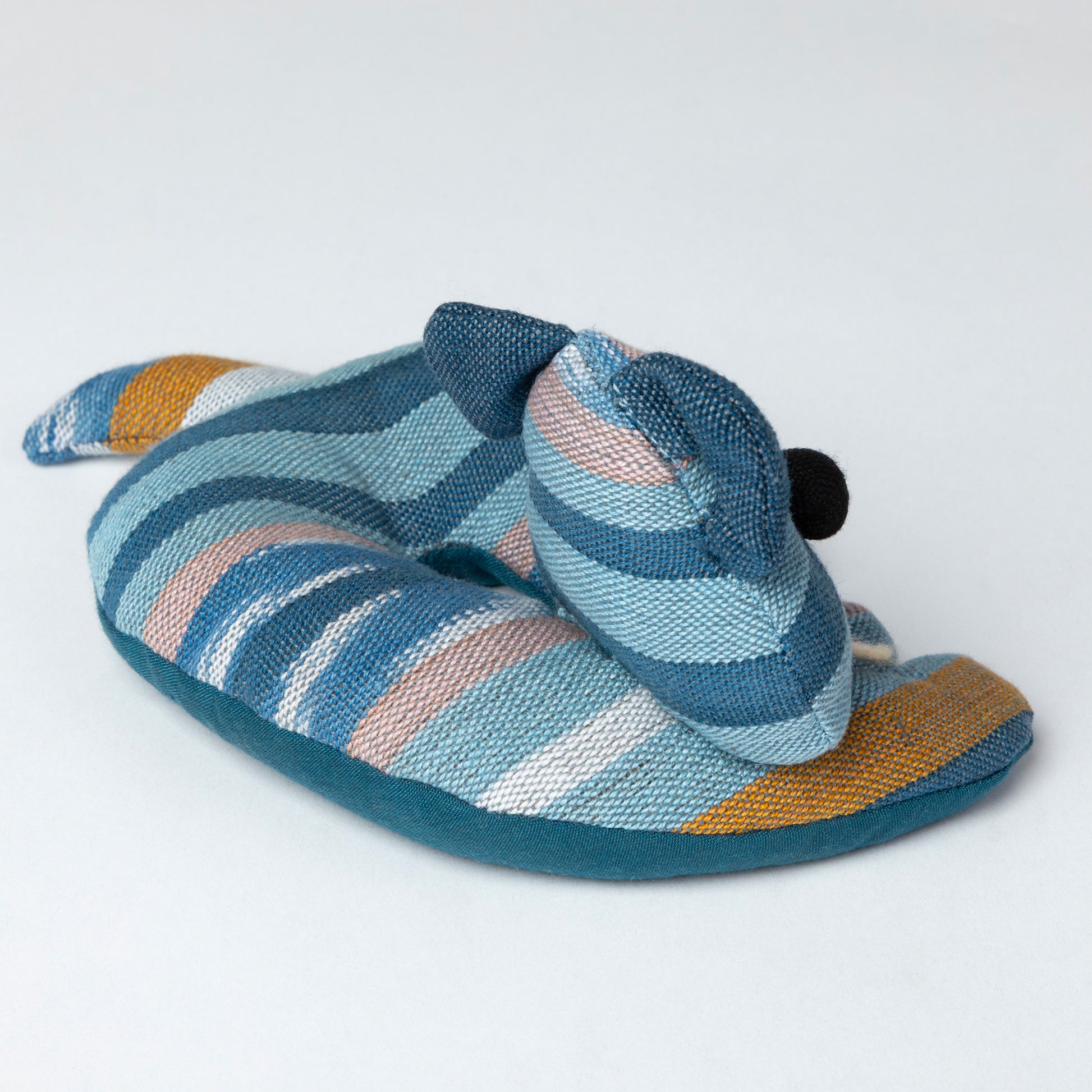 Striped coaster with blue, brown, and white pattern on a light gray background