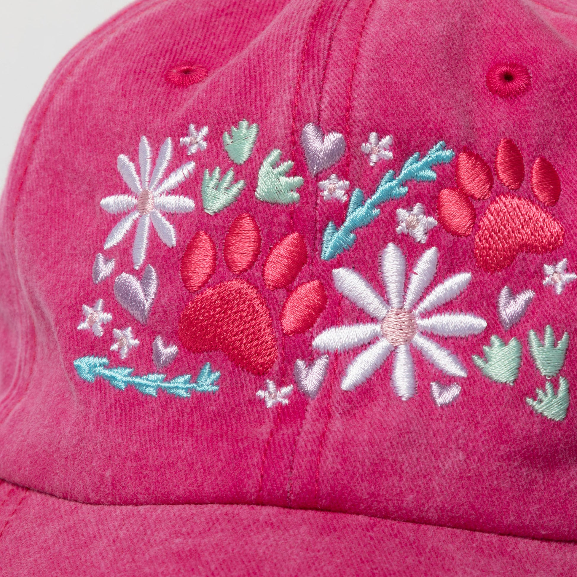 Pink cap with floral and paw print embroidery on a white background