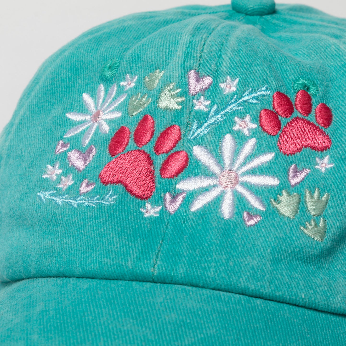 Teal cap with pink paw prints and white flowers on a white background