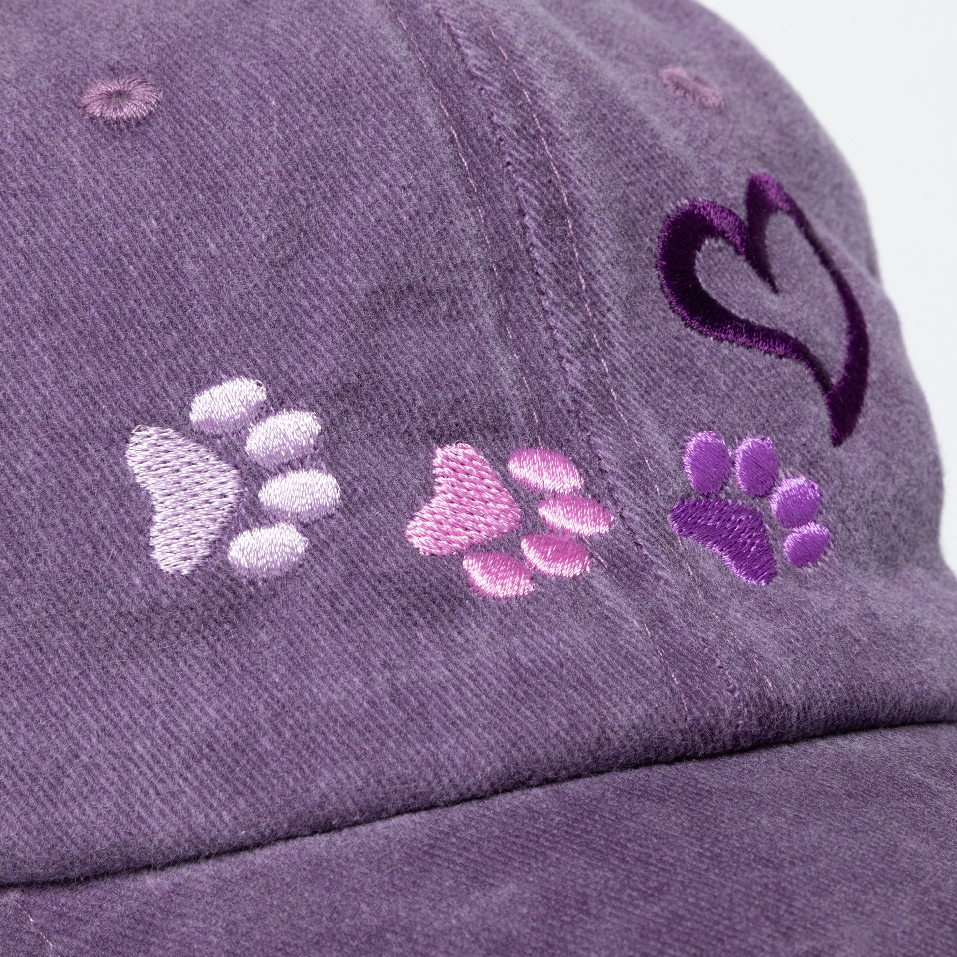 Purple cap with paw print designs on a white background