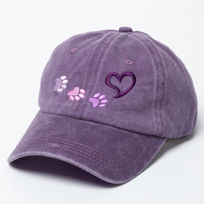 Purple cap with heart and paw print designs on a white background